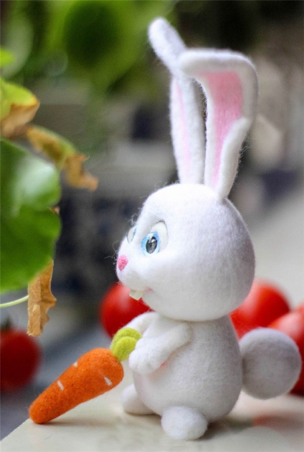 Cute cute handmade wool felt white rabbit holding a carrot