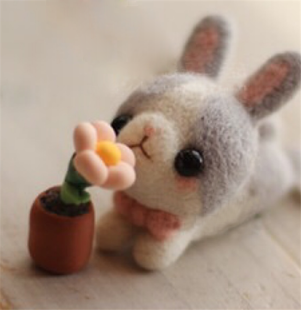 Cute and adorable handmade wool felt DIY production of little gray rabbits and flowers