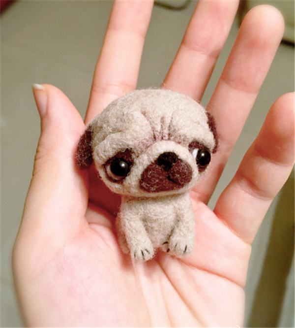 DIY pug made from wool felt with a disgusted look on his face