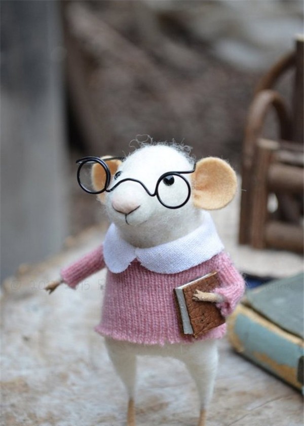 A creative work of a cute little mouse who loves reading made from handmade wool felt DIY