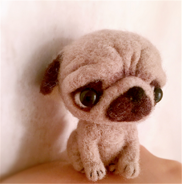 DIY pug made from wool felt with a disgusted look on his face