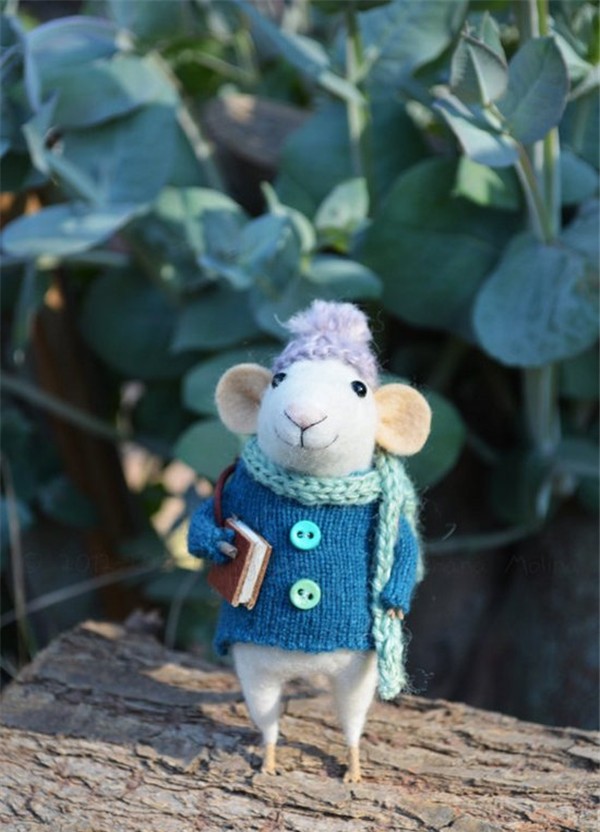 A creative work of a cute little mouse who loves reading made from handmade wool felt DIY