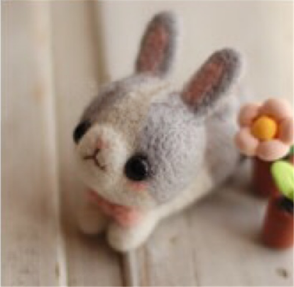 Cute and adorable handmade wool felt DIY production of little gray rabbits and flowers