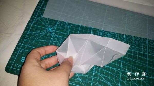 Illustration of the manual origami process of a simplified hexagonal box