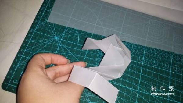 Illustration of the manual origami process of a simplified hexagonal box