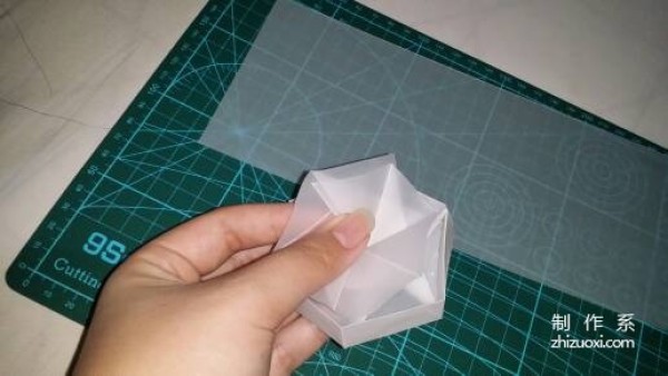 Illustration of the manual origami process of a simplified hexagonal box