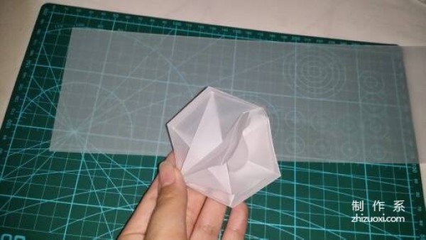 Illustration of the manual origami process of a simplified hexagonal box