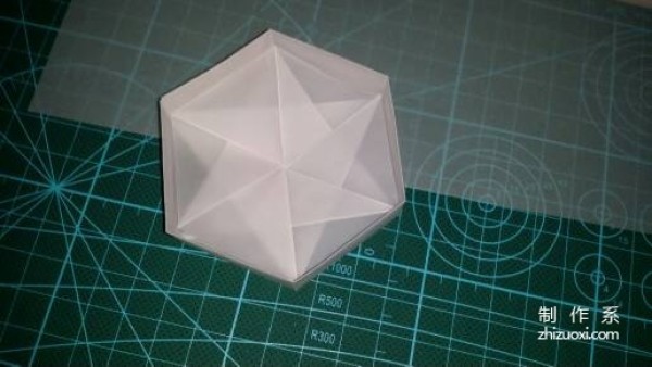 Illustration of the manual origami process of a simplified hexagonal box