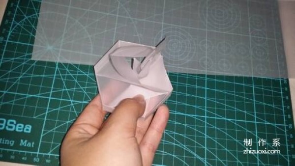 Illustration of the manual origami process of a simplified hexagonal box