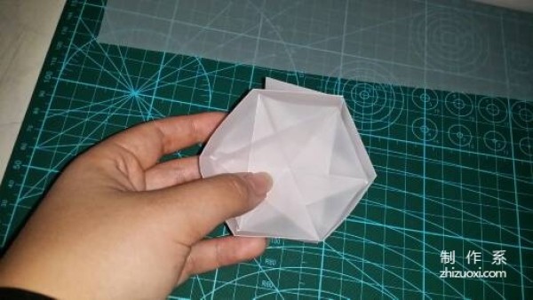 Illustration of the manual origami process of a simplified hexagonal box