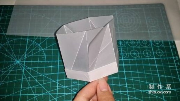 Illustration of the manual origami process of a simplified hexagonal box