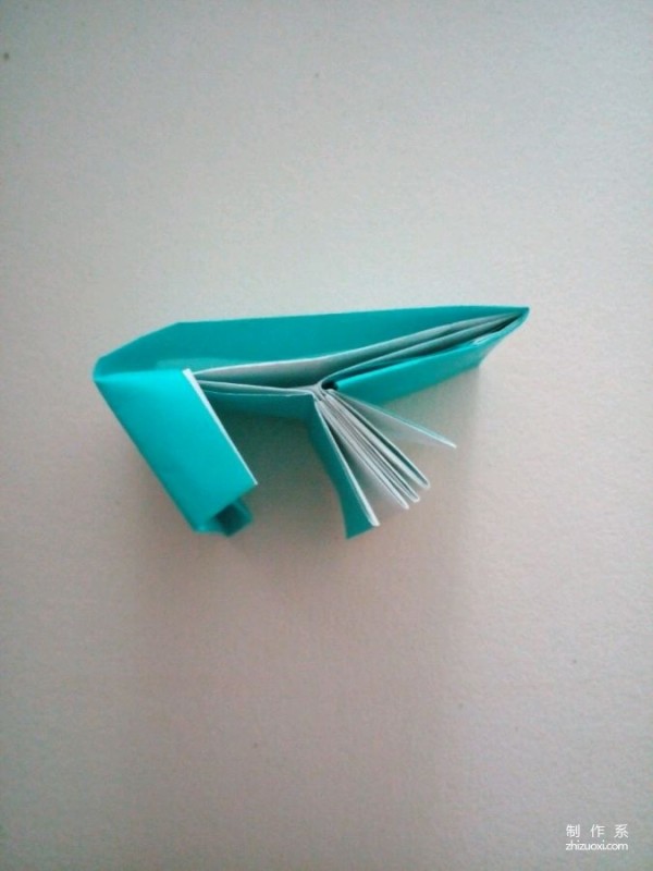 A creative origami real-life tutorial on a mini three-dimensional book-shaped book that can be folded out of just one piece of paper