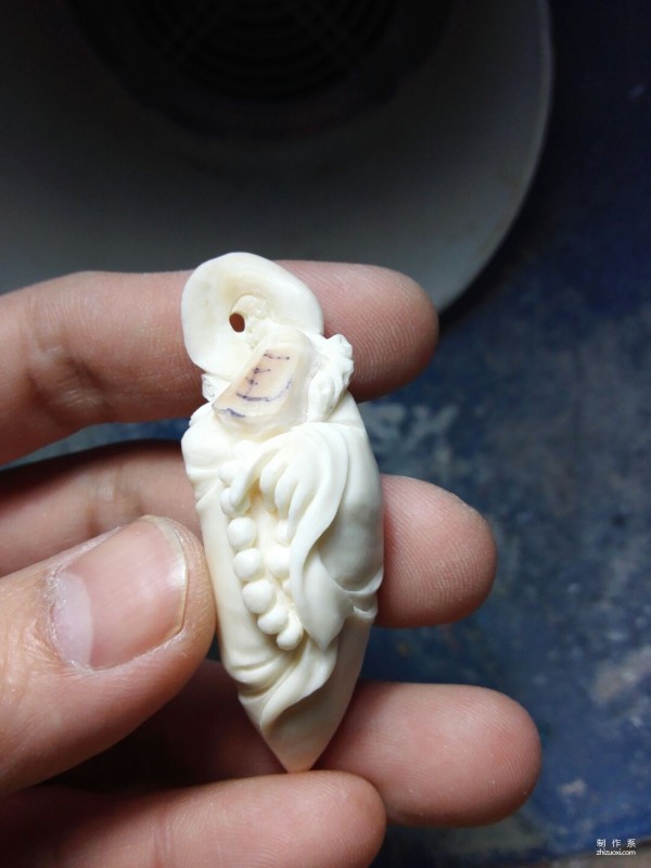 Manual method of hand carving Zen Zu bone carving ornaments using walrus molar teeth