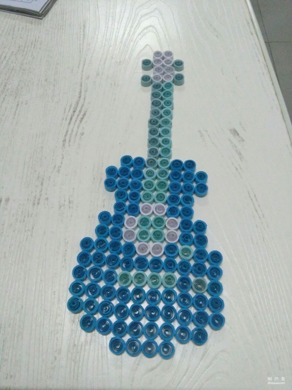 Manual tutorial on DIY paper quilling and drawing guitar pattern on crepe paper