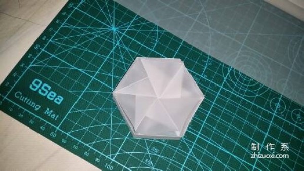 Illustration of the manual origami process of a simplified hexagonal box