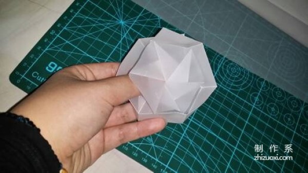 Illustration of the manual origami process of a simplified hexagonal box