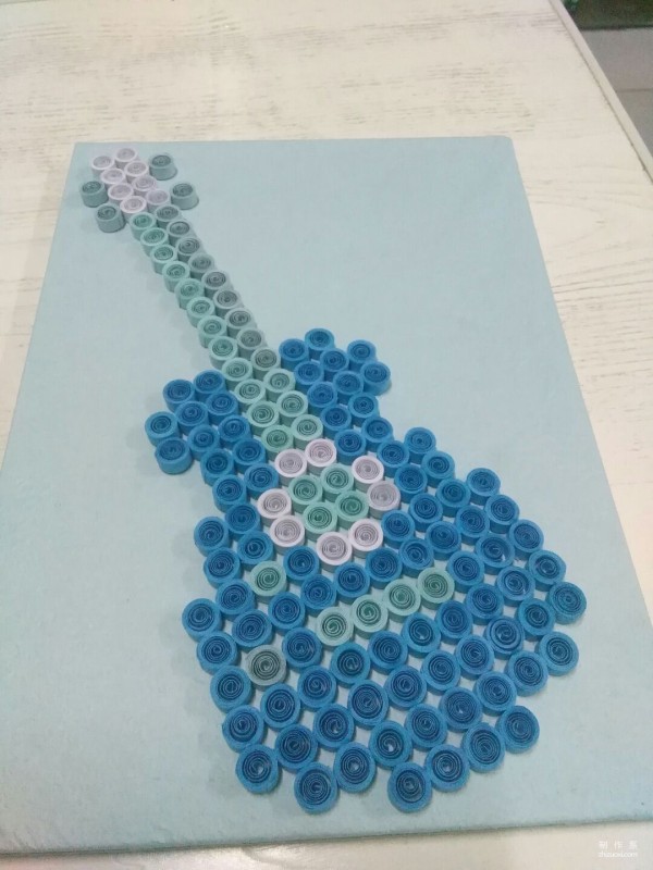 Manual tutorial on DIY paper quilling and drawing guitar pattern on crepe paper