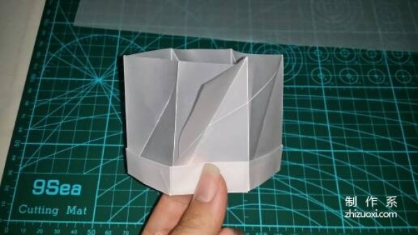 Illustration of the manual origami process of a simplified hexagonal box